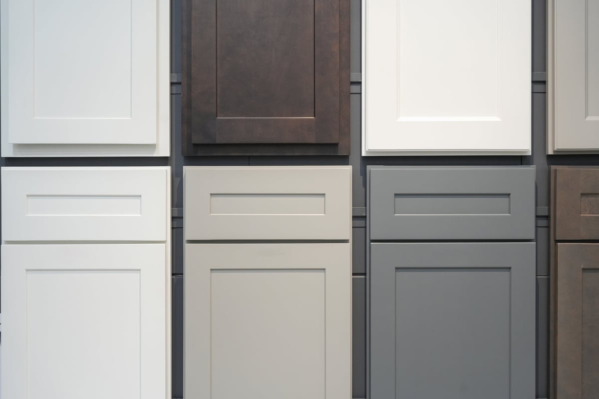 Cabinet door finish samples displayed on a workshop wall